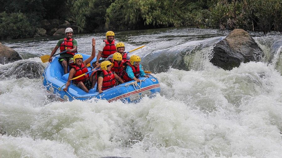  A raft with six people in safety gear navigating through a rough river, showing intense concentration and teamwork in an exhilarating environment.