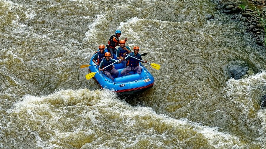 Aerial view of river rafting on a flowing river, showcasing the excitement of adventure amidst the natural landscape.