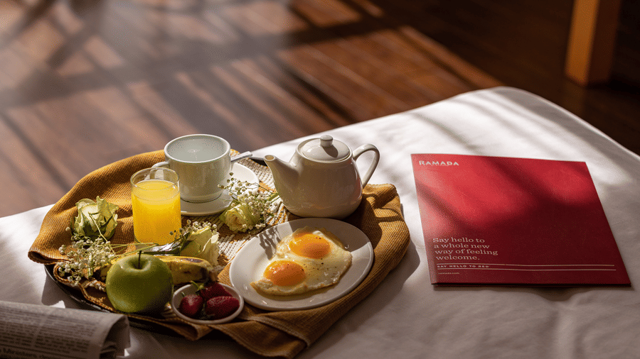 A close up of a tray containing many breakfast items that is placed on a bed - Ramada by Wyndham Addis, Addis Ababa.