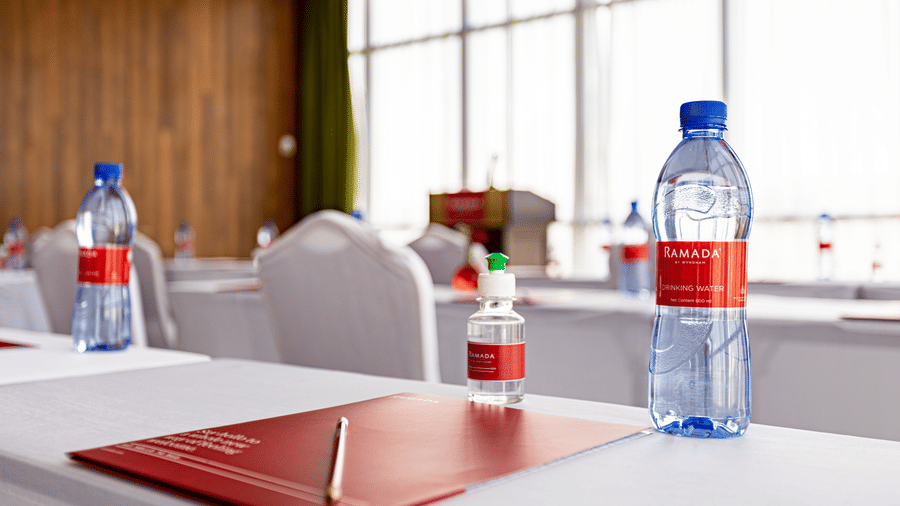 A close up shot of a table with a water bottle, pen and a book placed on a table - Ramada by Wyndham Addis, Addis Ababa.