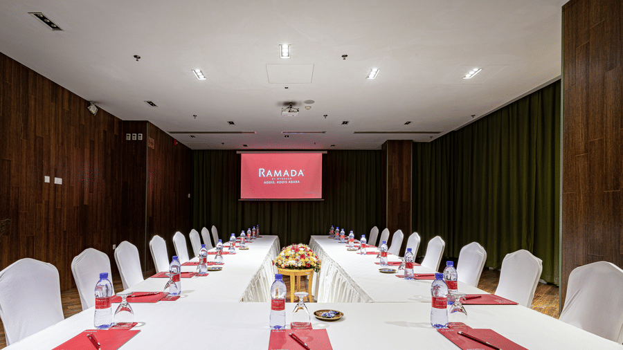 An overview of a meeting room with a U-shaped table and chairs in view - Ramada by Wyndham Addis, Addis Ababa.