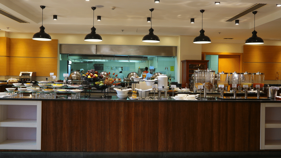 An overview of the buffet area with many items kept on the counter inside one of the restaurants - Ramada by Wyndham Addis, Addis Ababa.