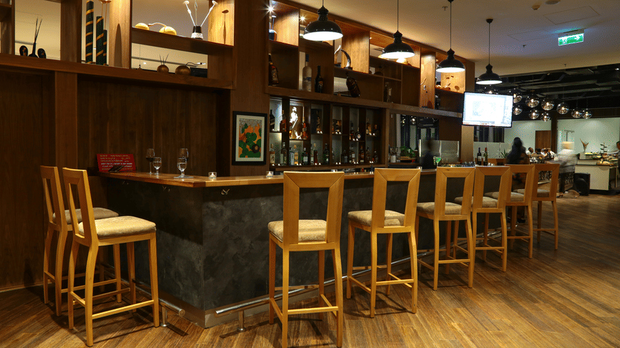 An overview of the bar area with many chairs and a bar counter in view - Ramada by Wyndham Addis, Addis Ababa.