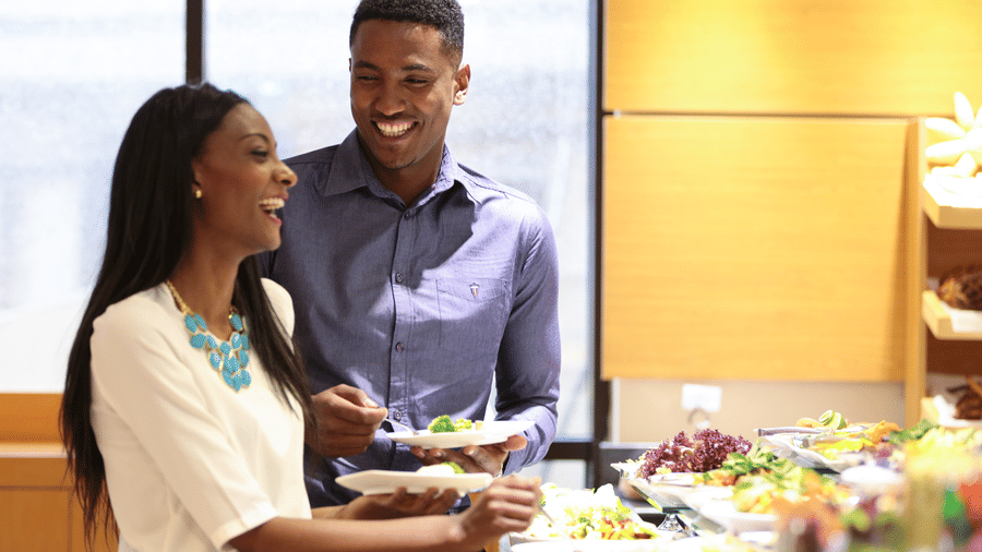 A couple laughing while taking food from the buffet area - Ramada by Wyndham Addis, Addis Ababa.