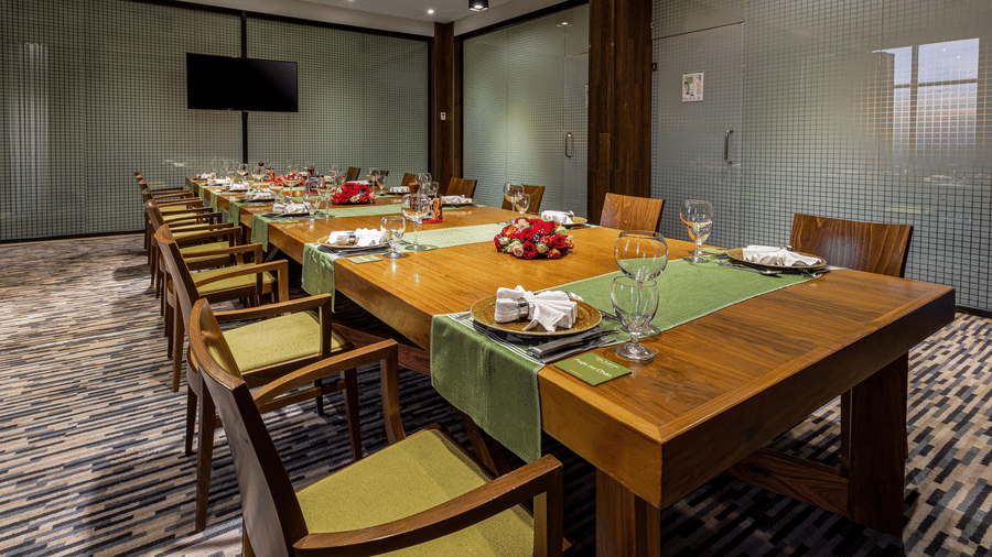 An overview of a large dining table with many chairs and items kept on the table inside FOGO NO CHÃO - Ramada by Wyndham Addis, Addis Ababa