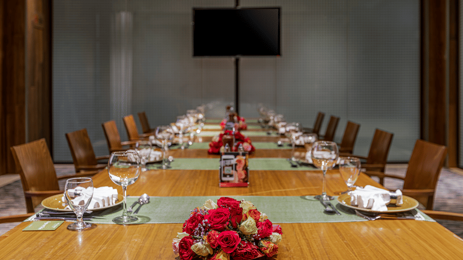 A close up shot of the dining table with many chairs and items kept on it inside FOGO NO CHÃO - Ramada by Wyndham Addis, Addis Ababa