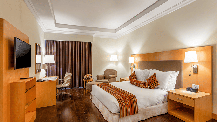 A room featuring a double bed with side tables and lamps on them at Ramada by Wyndham Addis, Addis Ababa.