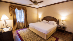 A room with a commodious king size bed and wooden flooring at The Clarton for a comfortable stay in Kodaikanal.