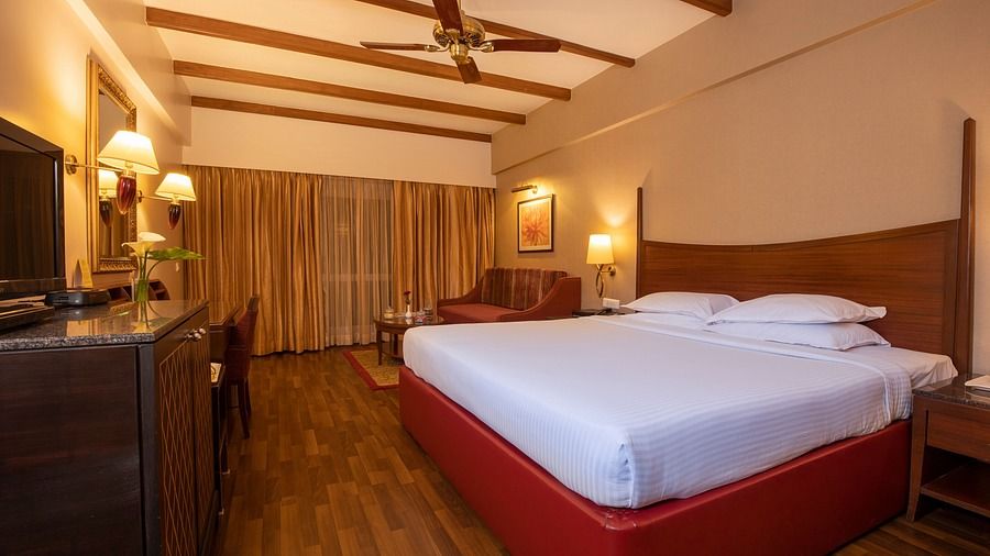 An image of a bedroom at The Carlton featuring a bed, a flat TV screen, etc 