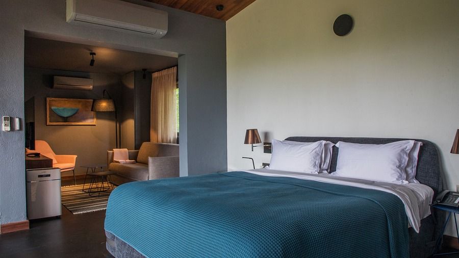 A king size bed in a V Suite with a sitting area in the other room- Villa in Palms by V Escapes