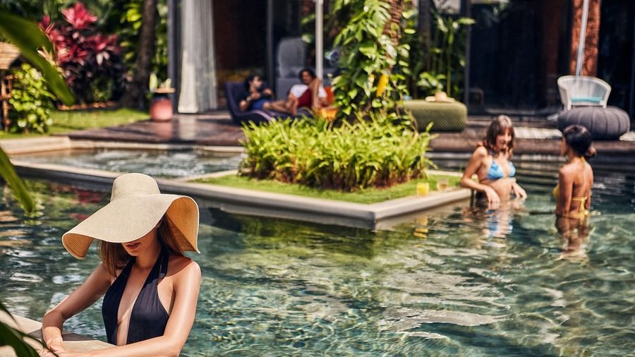 People relaxing in the clear waters of the Goa villa with private pool at Villa in Palms by V Escapes