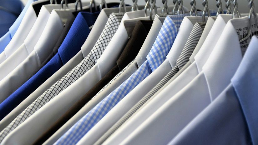 Close-up view of freshly laundered and neatly pressed dress shirts hanging on a rail at a professional laundry facility.