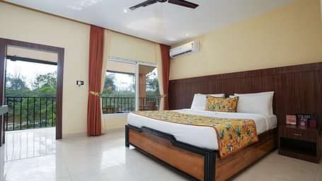 Premium room with balcony offering a nature view and spacious bed at Summit Green Lake Tea Resort & Spa, Kaziranga