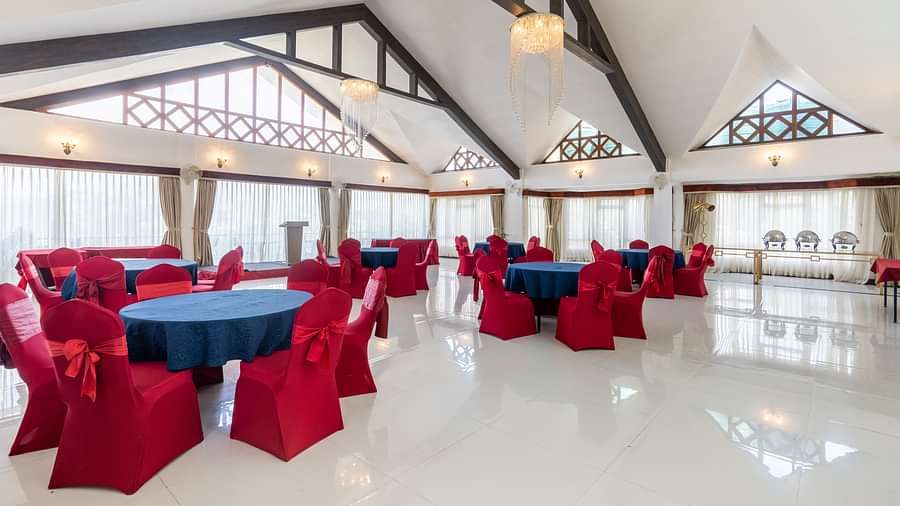 event hall with red chairs and blue table at Summit Lillium Hotel & Spa, Kalimpong
