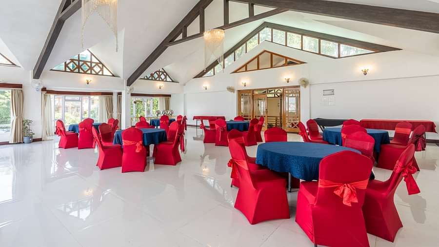 event hall with red chairs and blue table at Summit Lillium Hotel & Spa, Kalimpong