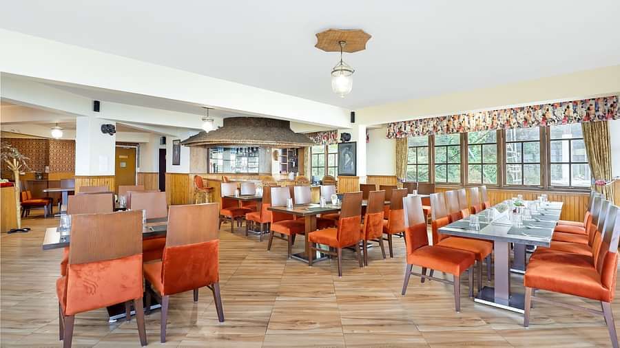 A full view of multiple dining tables and chairs placed in a closed hall | Summit Newa Regency & Spa, Pelling