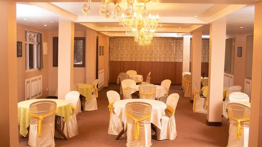 Multiple round tables and chairs placed in a closed hall that has chandeliers | Summit Oakden Resort & Spa, Mall Road