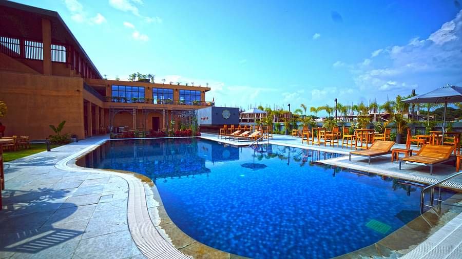 Outdoor swimming pool at Singalila Club with lounging chairs placed around the periphery