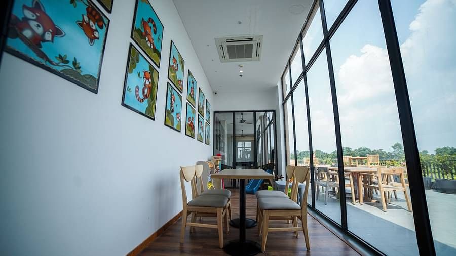 Dining arrangement at Singalila Club with large French windows letting in light during a slightly cloudy day
