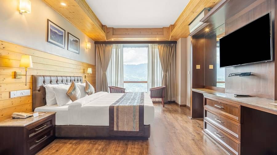 Deluxe room at Summit Alpine Abode with a double bed, a television and French windows