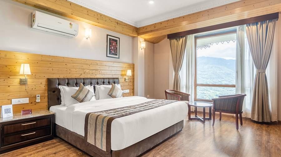 Deluxe room at Summit Alpine Abode with a double bed, seating arrangement and French windows