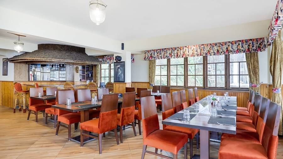 Multiple dining tables and chairs placed in a closed hall | Summit Newa Regency & Spa, Pelling