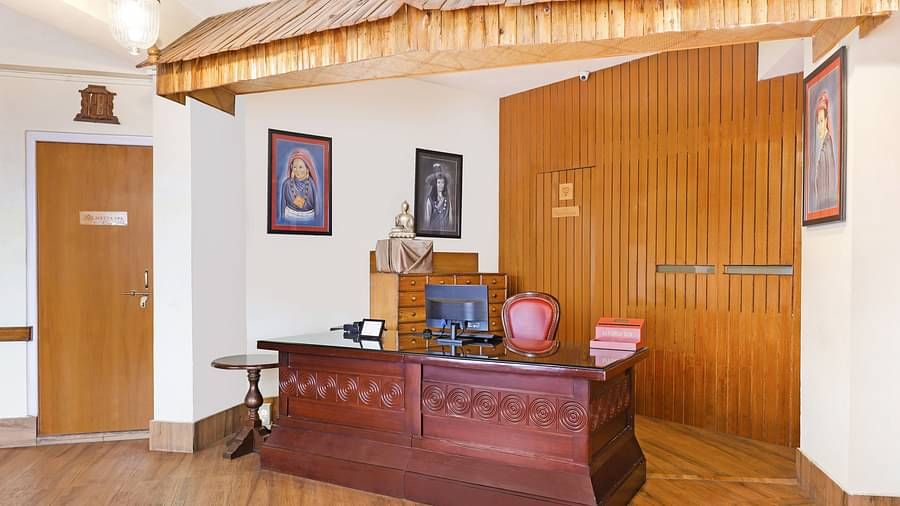 A front view of reception area that has a desk, chair, and a desktop | Summit Newa Regency & Spa, Pelling