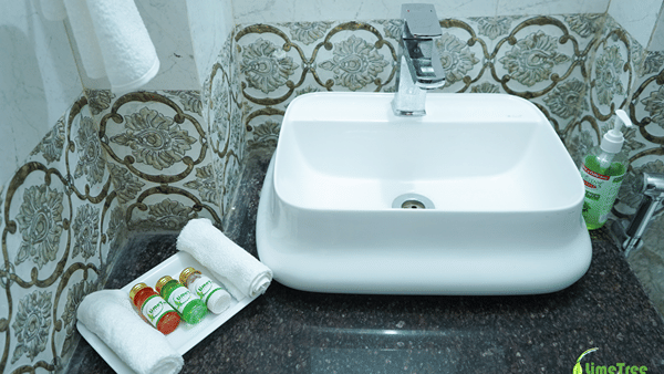 Bathroom vanity with a white vessel sink and LimeTree bath amenities at Lime Tree Hotel Near 32nd Avenue.