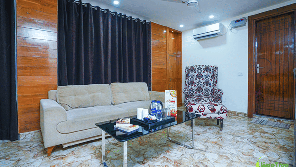Seating area with a beige sofa, damask wingback chair and a Signature Kitchen menu at Lime Tree Hotel Near 32nd Avenue.