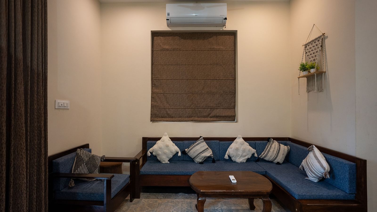 Image of a seating area with sofas and an air-conditioner above the window at Aanandam Resort & Spa, Pushkar.