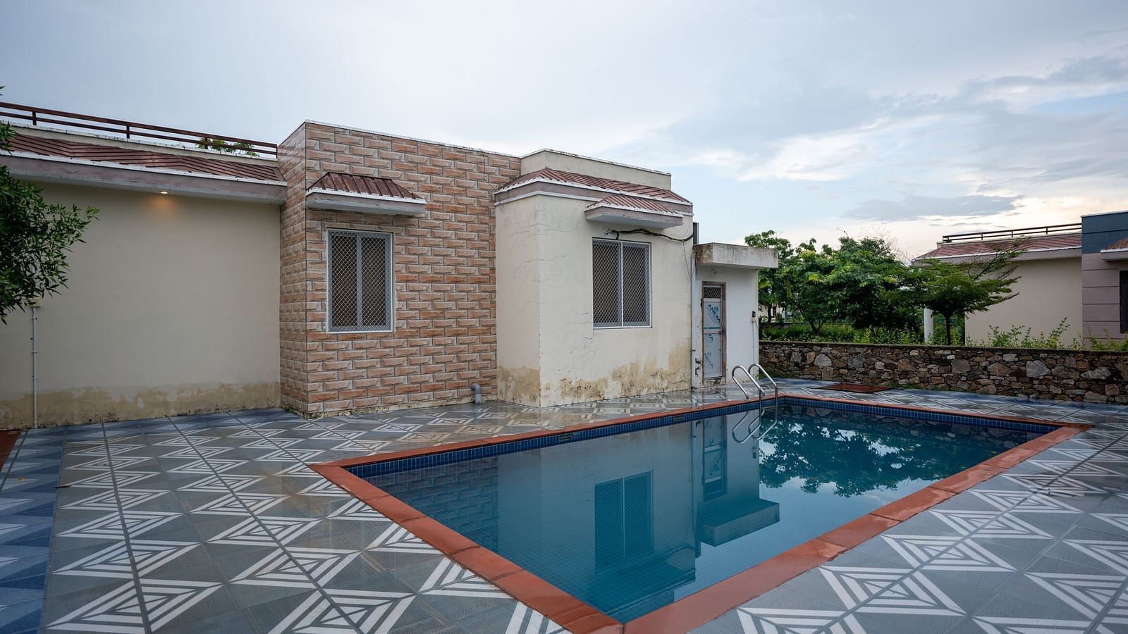 Image of an outdoor swimming pool with a building on the side at Aanandam Resort & Spa, Pushkar.