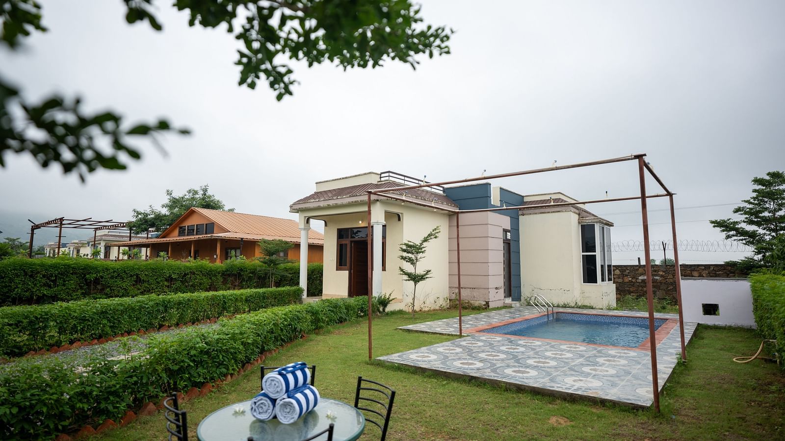 Facade of an accommodation with an outdoor swimming pool and a seating area beside it at Aanandam Resort & Spa, Pushkar.