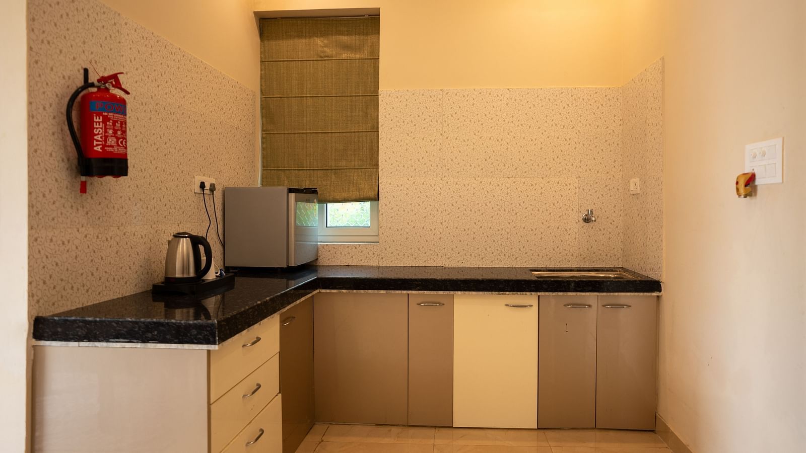 Image of a kitchen with a kettle and mini fridge at Aanandam Resort & Spa, Pushkar.