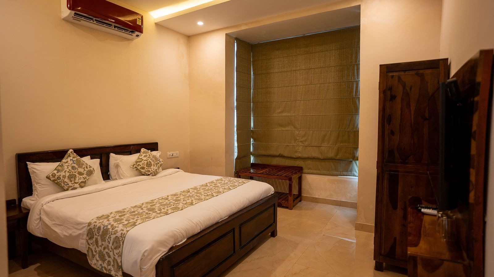 Image of a room with bed and a television in front of it at Aanandam Resort & Spa, Pushkar.