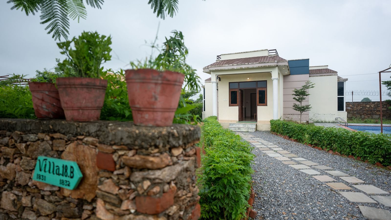 Facade of an accommodation with the pathway paved with stones at Aanandam Resort & Spa, Pushkar.