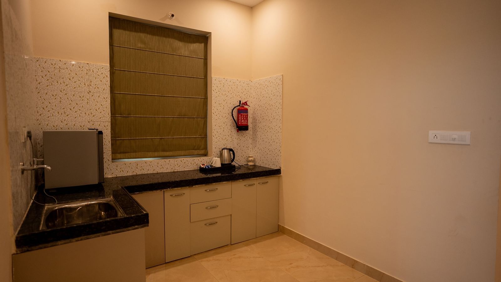 Image of a kitchen with a mini fridge and kettle at Aanandam Resort & Spa, Pushkar.