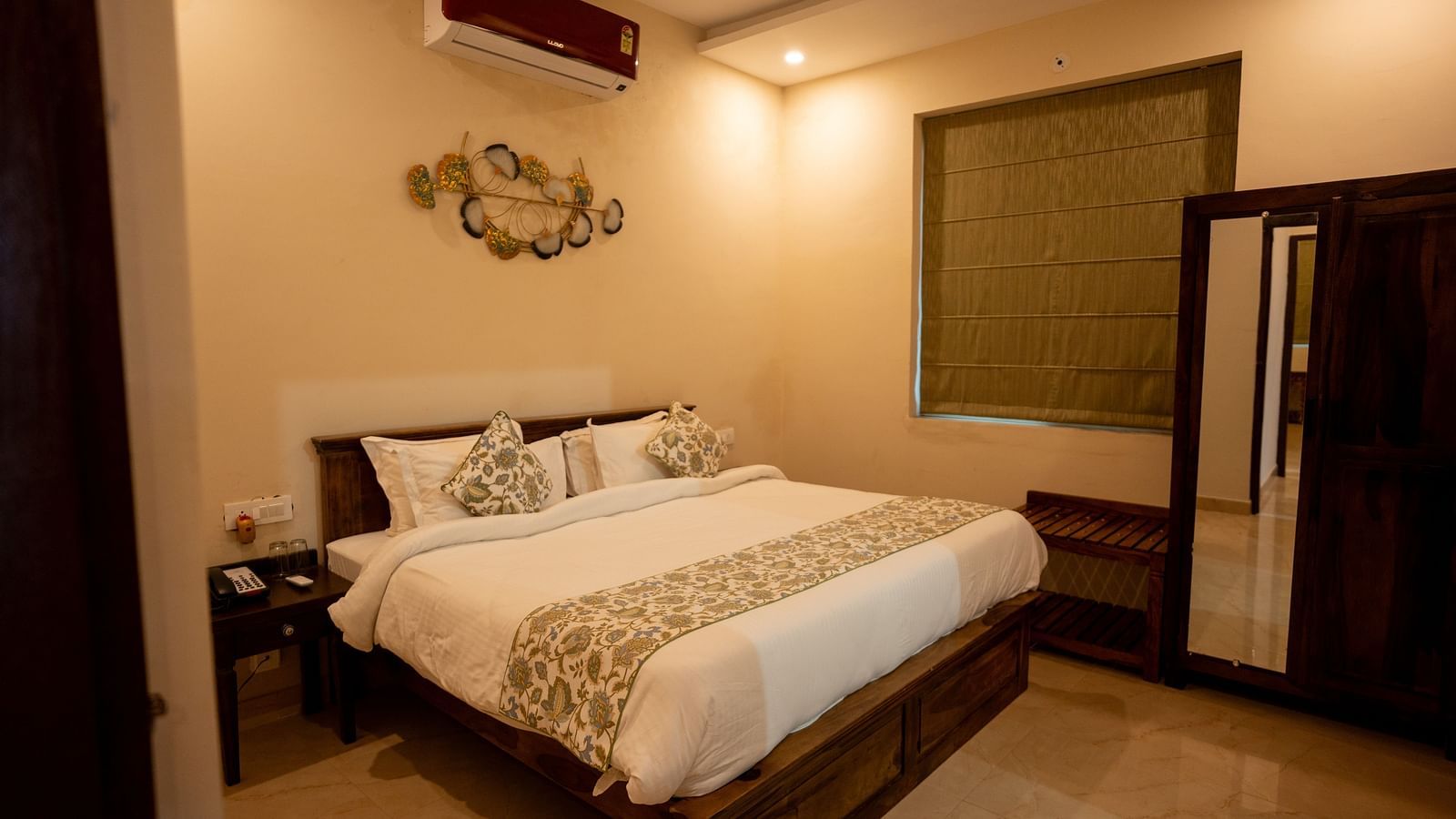 Image of a room with bed, wardrobe and window on the side at Aanandam Resort & Spa, Pushkar.