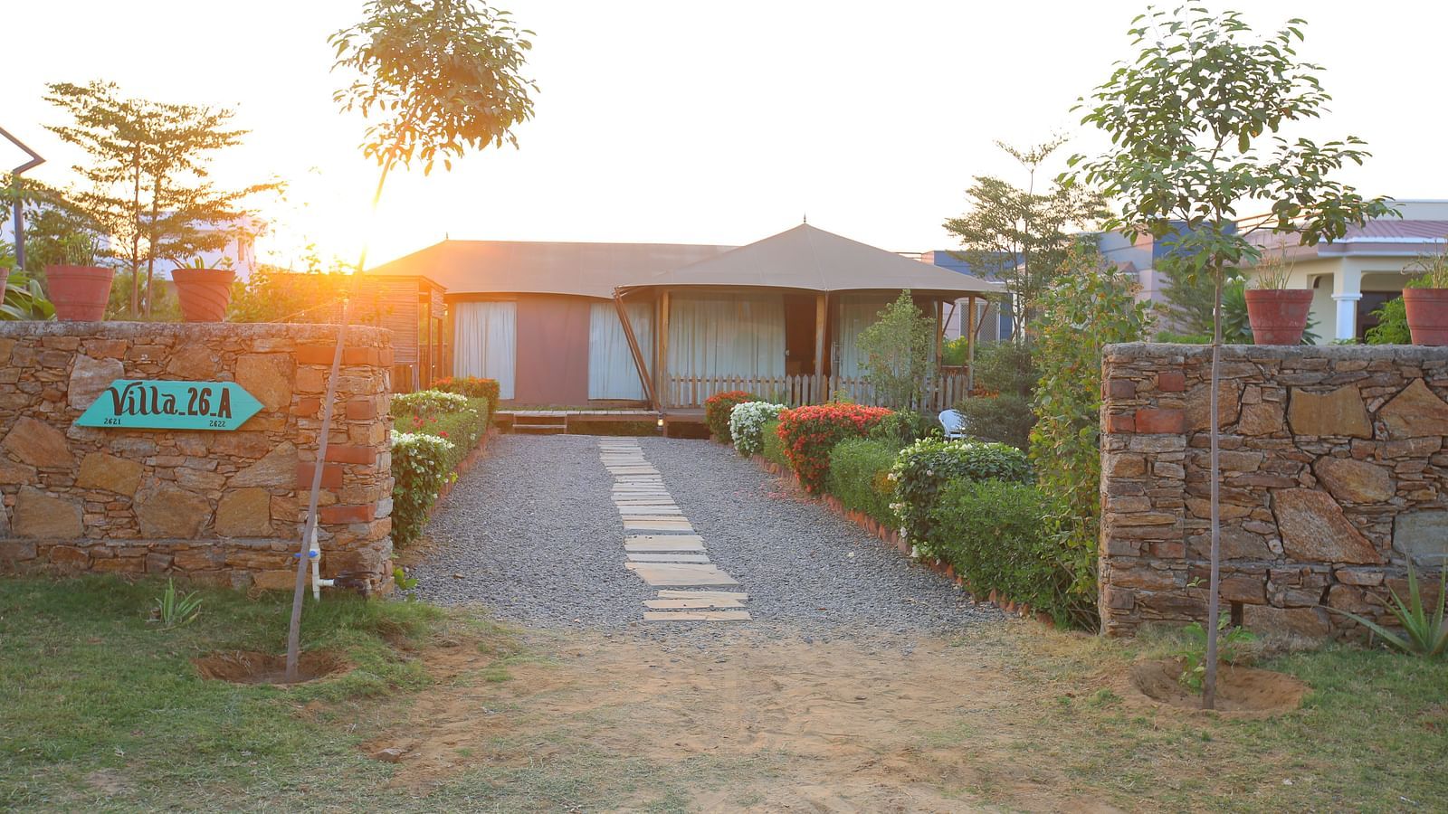 Front view of the Luxury Wooden Tent, with vibrant plants lining the pathway at Aanandam Resort & Spa
