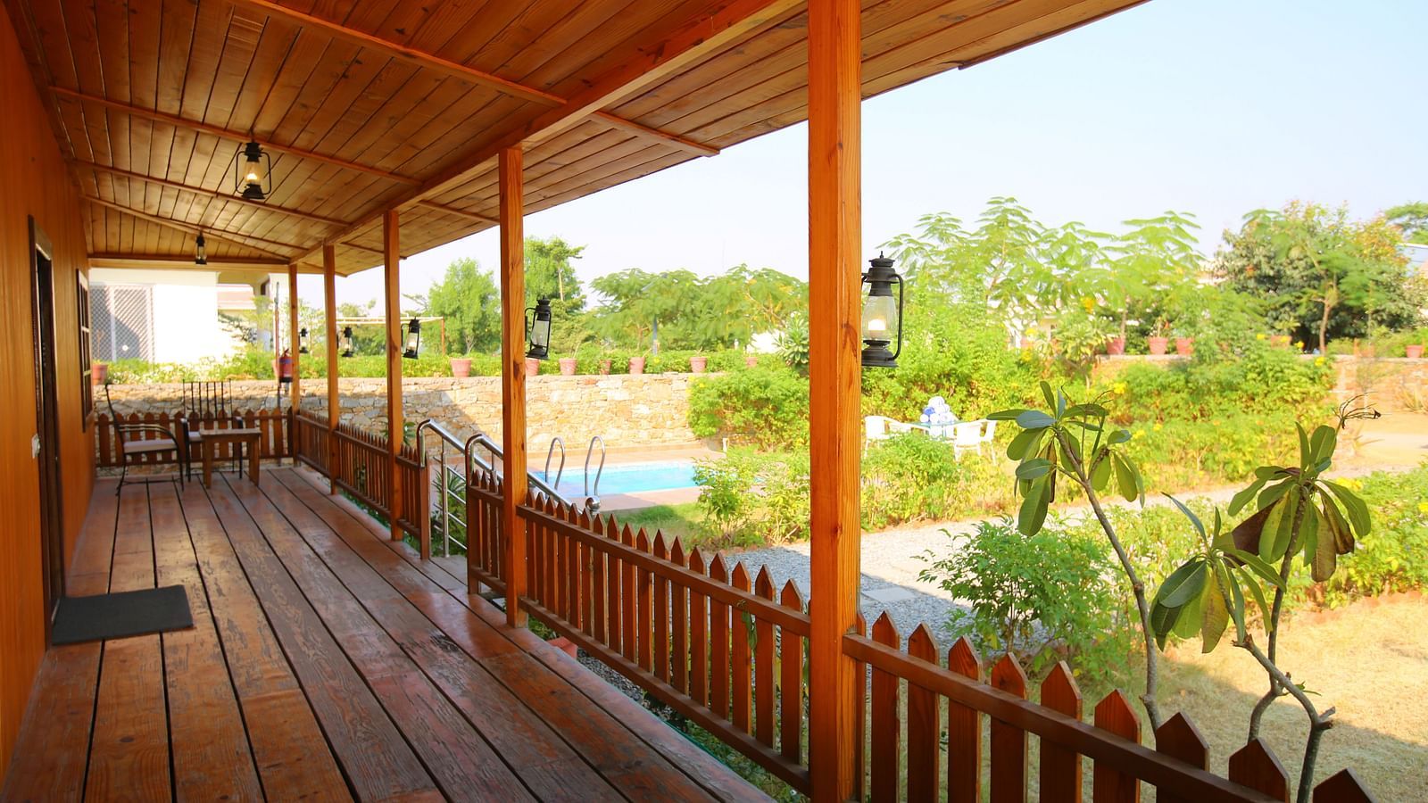 Balcony of Kashmir Cottage Villa's Pool room offering a serene view of the garden at Aanandam Resort & Spa