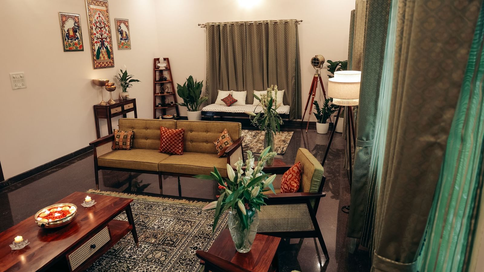 A living room with a brown sofa, armchairs, a coffee table, and various decorative items | Adhyaya Heritage Reverbed