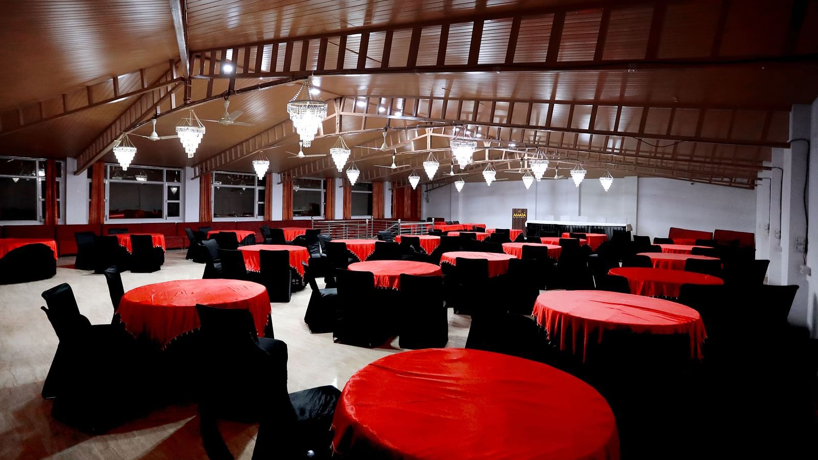 Image of a dining hall with round tables and chairs around it at Amara Hill Queen, Mussoorie.