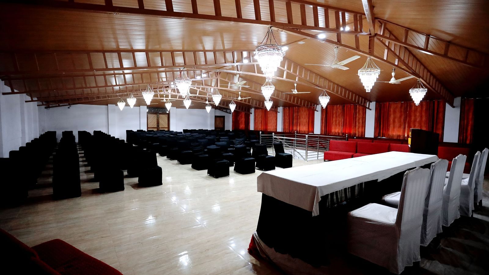 Image of a banquet hall with chairs and a pulpit in front at Amara Hill Queen, Mussoorie.
