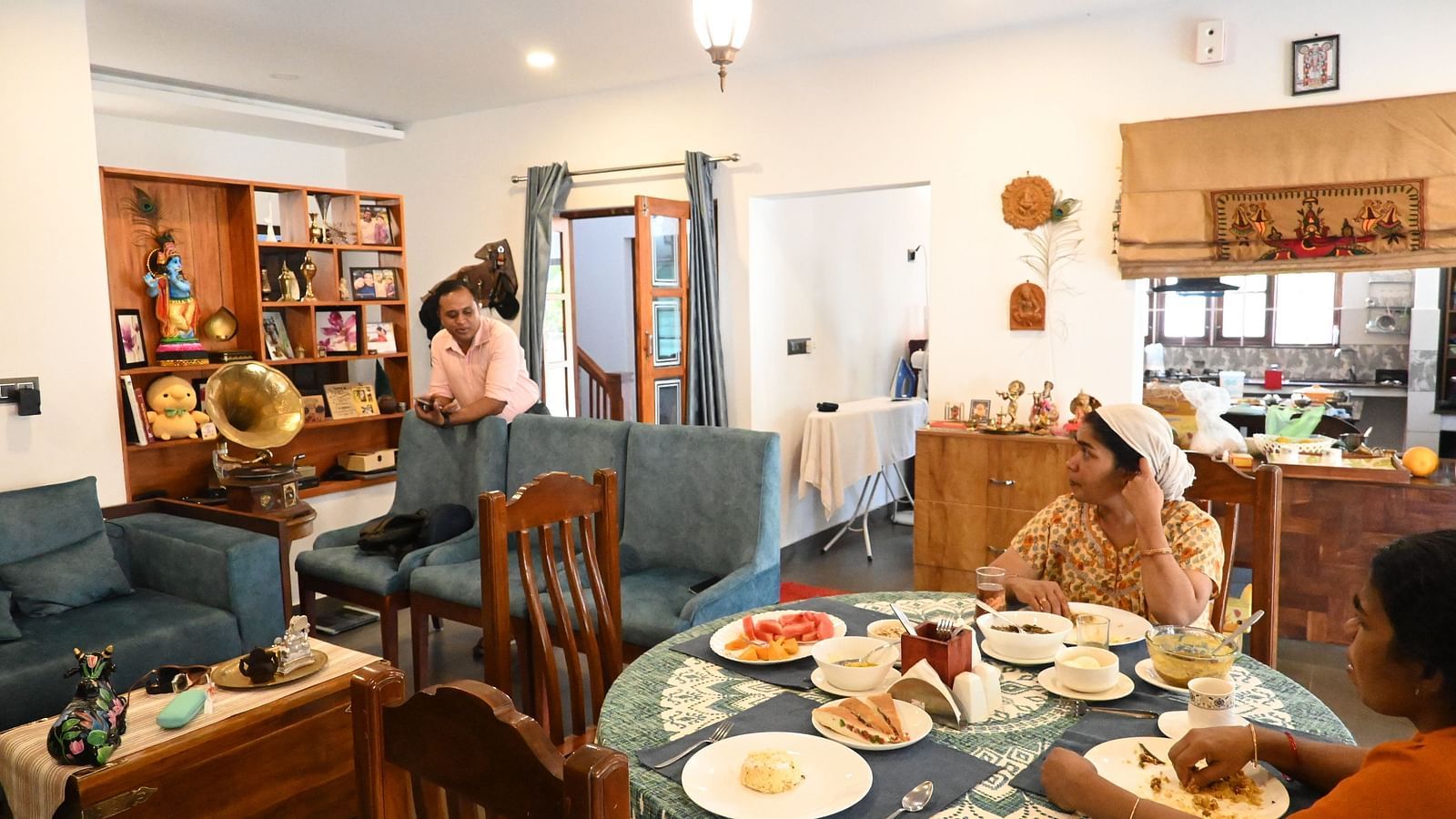 Dining area at Ananda Holiday Home, Wayanad with people sitting at the dining table with food in front of them