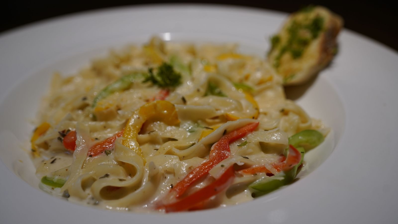 An image of a white sauce pasta placed on a table - Argo By Trance, Goa
