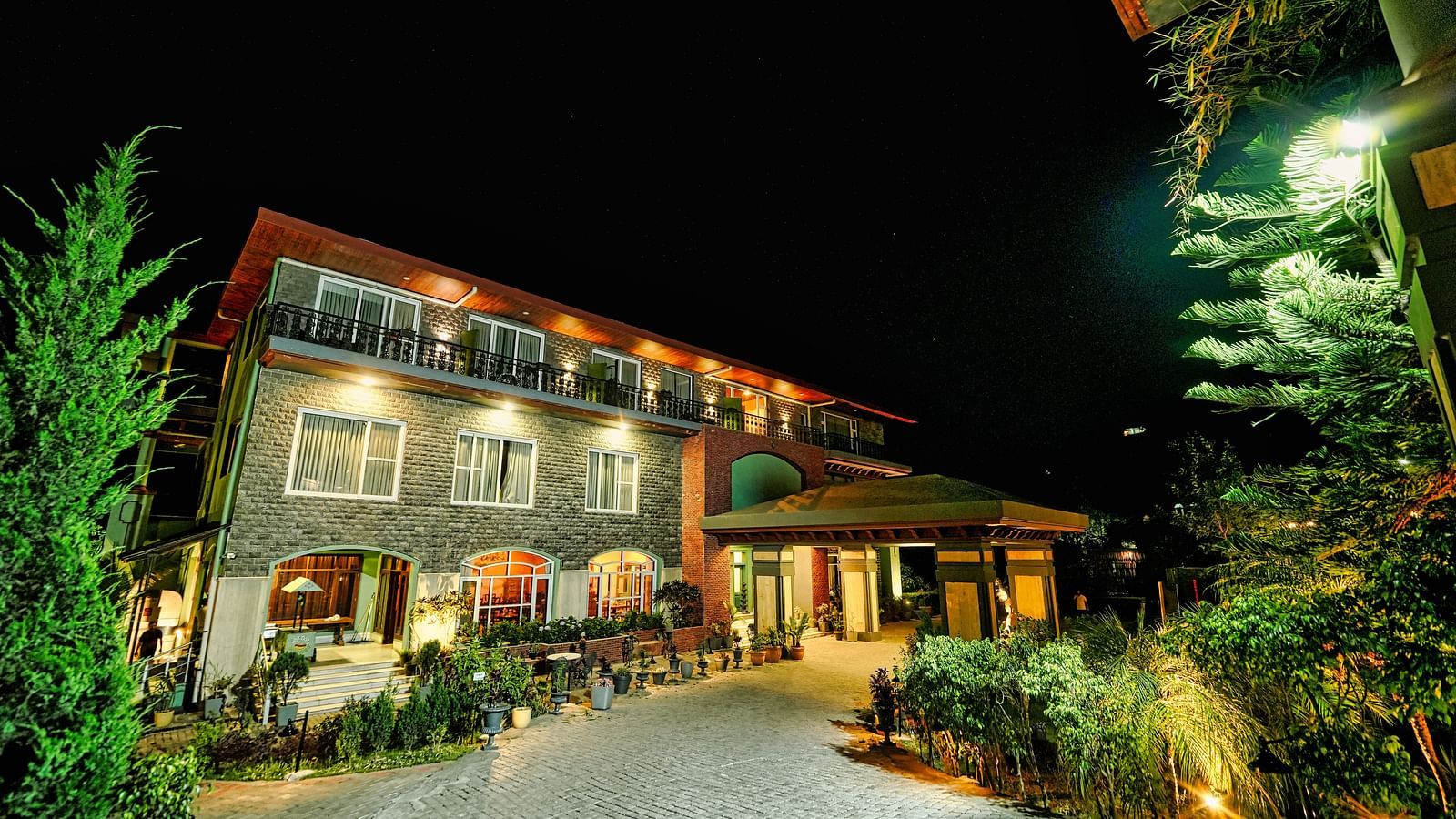 A picture of Atman, Dharamshala luxurious entrance with beautifully lit lighting and lawn area