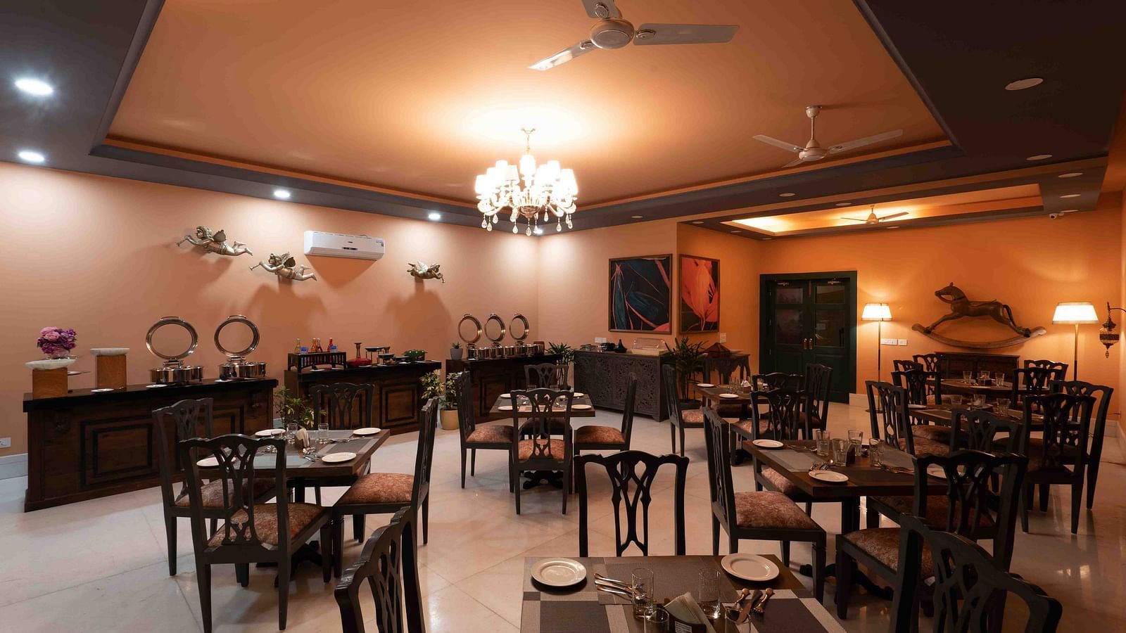 An image of spacious restaurant at atman, dharamshala with high ceilings and large windows, offering a bright and airy atmosphere.