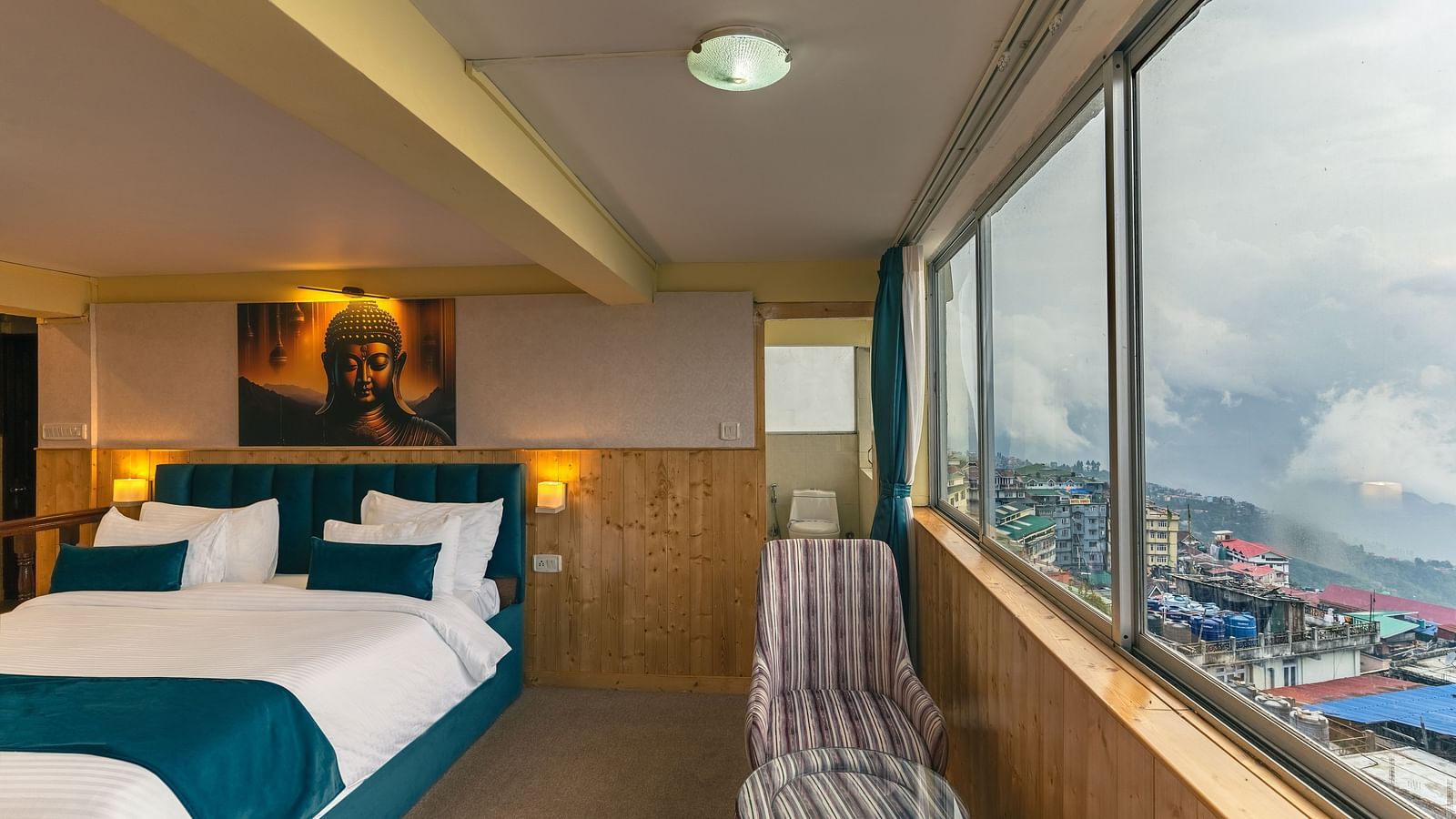 Image of a room with bed and seating area and large glass at Seven Seas