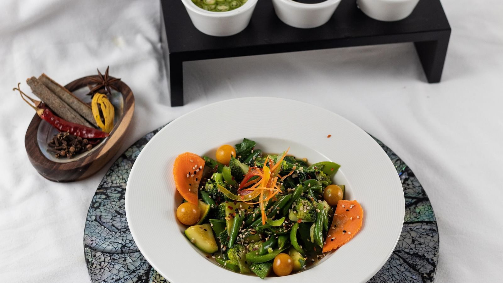Fresh salad with three colourful dips, presented elegantly, a light and healthy option.