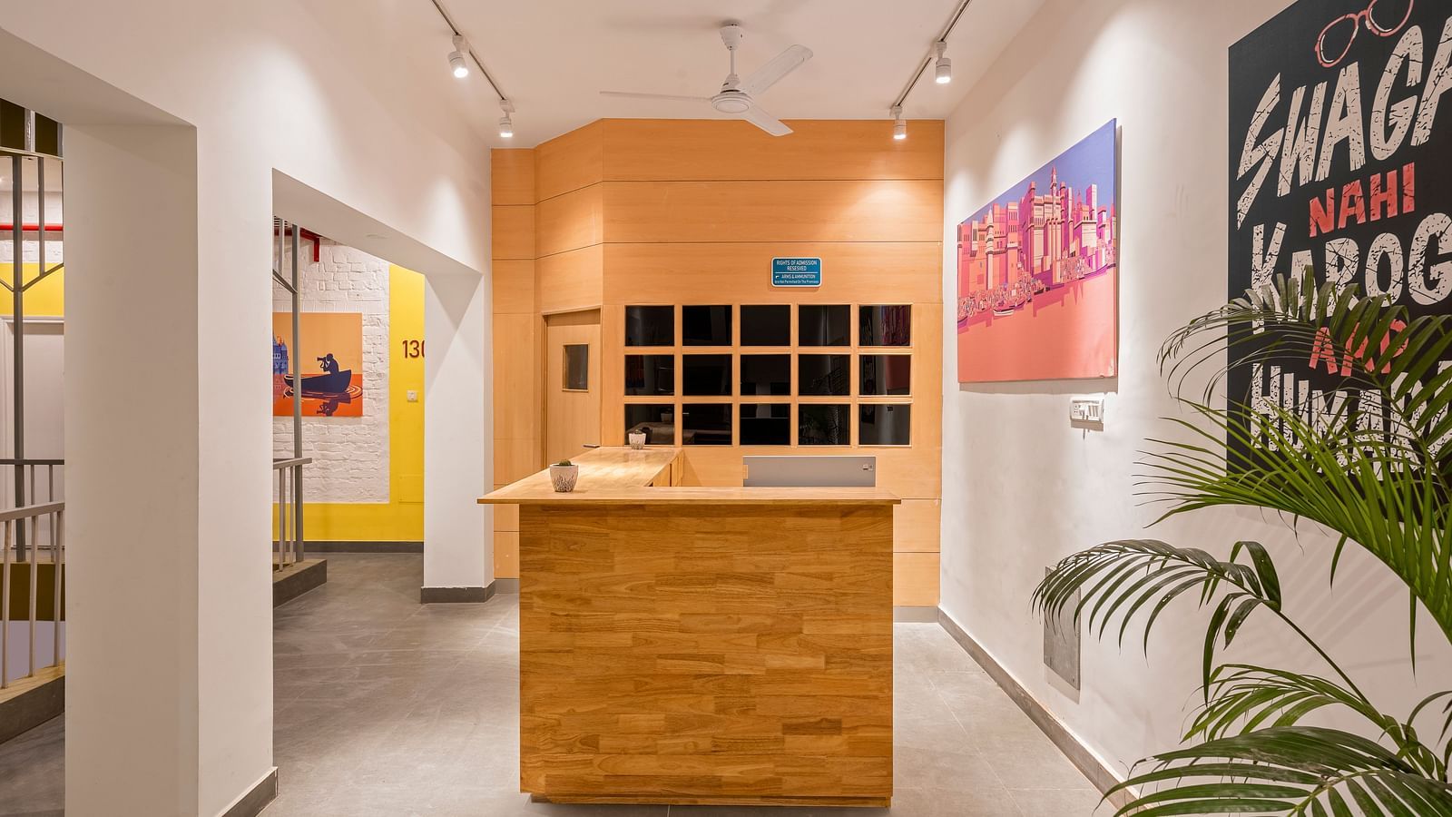 A picture of the reception area at Bedzzz Varanasi, with wooden desk and posters on wall.