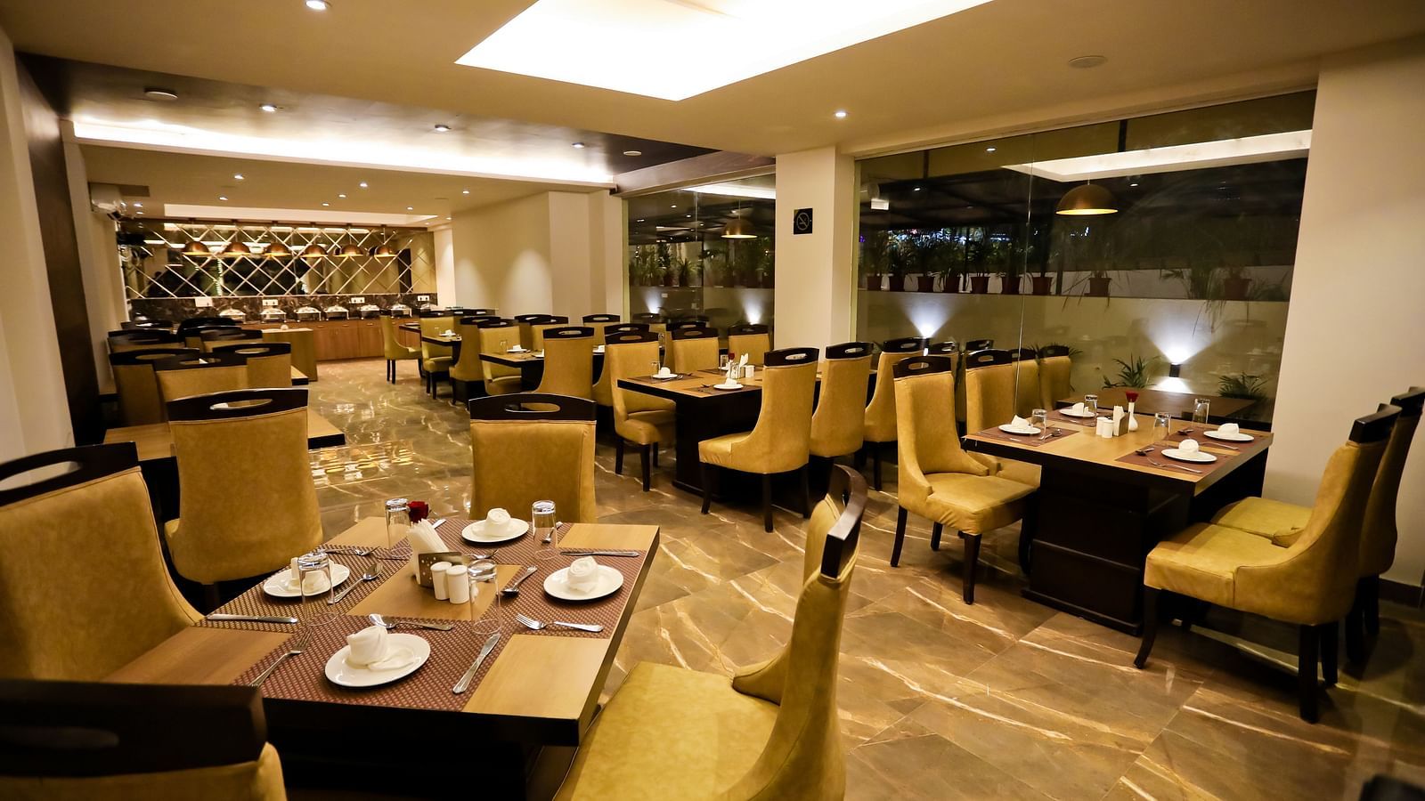 Image of a dining space with crockery placed on the tables and chairs surrounding it at Calux Grand Baga.